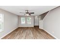 Bright living room with hardwood floors, a ceiling fan, and natural light from the large double windows at 1023 Saint Augustine Pkwy, Locust Grove, GA 30248