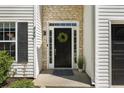 The home features a black front door with sidelights and a green wreath accent at 429 Tannenhill Pl, Sugar Hill, GA 30518