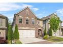 Charming two-story brick home featuring a two-car garage and a beautifully landscaped front yard at 1908 Weston Ln, Tucker, GA 30084