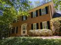 Classic brick home with black shutters, an arched entryway, and lovely landscaping creating a welcoming facade at 3573 Turtle Cove Se Ct, Marietta, GA 30067