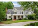 Beautiful two-story home featuring blue siding, dark shutters, a welcoming front porch, and a well-manicured lawn at 492 Conway Manor Nw Dr, Atlanta, GA 30327