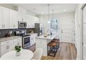 Modern kitchen with white cabinets, stainless steel appliances, and a stylish backsplash at 1095 Tucker Ave # 207, Atlanta, GA 30310