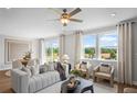Inviting living room with comfortable seating, large windows, and an open layout to the dining area at 126 Kenney Way, Locust Grove, GA 30248