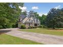 Inviting two-story home with manicured lawn, stone details, and a long driveway leading to the house at 2305 Lochinver Sw Ln, Conyers, GA 30094