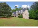 Two-story home featuring stone accents and lush landscaping, set on a spacious lot with mature trees at 2305 Lochinver Sw Ln, Conyers, GA 30094