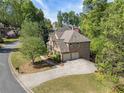 Aerial view of brick home, two-car garage, and surrounding mature trees at 1459 Hickory Branch Nw Trl, Kennesaw, GA 30152