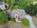 Overhead view of brick home with mature landscaping, driveway, and surrounding greenery at 1459 Hickory Branch Nw Trl, Kennesaw, GA 30152