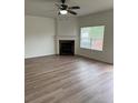 Bright living room featuring a cozy fireplace, neutral walls, laminate wood flooring and large windows at 290 Azalea Cir, Cumming, GA 30040