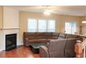 Spacious living room featuring hardwood floors, a fireplace, and large windows for natural light at 4208 Royal Regency Nw Cir # 9, Kennesaw, GA 30144
