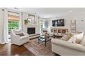 Cozy living room featuring a painted brick fireplace, large windows, and comfortable seating at 10 Wyndham Dr, Sandy Springs, GA 30328