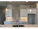 Bright kitchen features white cabinets, marble countertops, stylish backsplash, and modern pendant lighting at 146 Birch Tree Way, Cumming, GA 30040