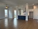 Bright, open-concept living room with hardwood floors seamlessly connects to a modern kitchen at 146 Birch Tree Way, Cumming, GA 30040