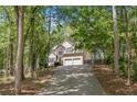 Beautiful home nestled among trees with a long driveway leading to a two-car garage at 160 Wentworth Dr, Canton, GA 30114