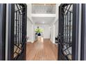 Grand foyer with hardwood floors, wrought iron door, and a view of the staircase and living area at 1900 Chattahoochee Run Dr, Suwanee, GA 30024