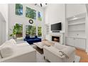 Bright living room with large windows, fireplace, and built-in bookshelves at 1900 Chattahoochee Run Dr, Suwanee, GA 30024