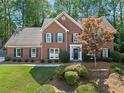 Beautiful brick home featuring a well-manicured lawn, symmetrical facade, and dark blue shutters at 4794 Dalhousie Ne Pl, Marietta, GA 30068