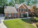 Traditional brick home on a well-maintained lawn, featuring a mature shade tree and dark blue shutters at 4794 Dalhousie Ne Pl, Marietta, GA 30068