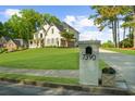 Exterior view of a landscaped front yard with a view of the house and mailbox with the address at 7390 Canter Run, Cumming, GA 30040