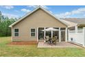 A backyard view showcasing a charming screened-in porch and a brick patio perfect for outdoor entertaining at 155 Point View Dr, Canton, GA 30114