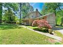 Spacious home with mature trees, a well-manicured lawn, and a two-car garage at 3157 Brooks Dr, Snellville, GA 30078