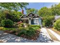 Charming craftsman-style home with blue exterior, inviting front porch, driveway and lush landscaping at 342 5Th Ne St, Atlanta, GA 30308