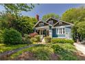 Charming craftsman-style home with blue exterior, inviting front porch, and lush landscaping at 342 5Th Ne St, Atlanta, GA 30308