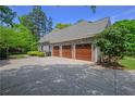 Spacious three-car garage with brick exterior and ample driveway space at 3590 Fricks Rd, Marietta, GA 30062