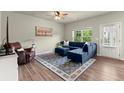 Cozy living room with hardwood floors, blue sectional sofa, and abundant natural light at 2110 Prichard Park Dr, Kennesaw, GA 30144