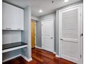 Hallway features a built-in desk, white cabinets, hardwood floors, and three doors at 3324 Peachtree Rd # 1719, Atlanta, GA 30326
