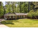 Beautiful brick home with an attached garage and a lush, green front lawn and mature trees at 1602 Shamrock Se Trl, Smyrna, GA 30080