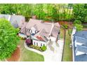 An aerial view of a brick home and manicured landscaping with a lengthy driveway at 1738 Honey Tree Pl, Hoschton, GA 30548