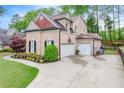 Brick home featuring a well-maintained lawn, beautiful landscaping, and a two-car garage at 1738 Honey Tree Pl, Hoschton, GA 30548