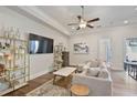 Bright living room with wood floors, a large sectional sofa, and decorative shelving at 690 Stickley Oak Way, Woodstock, GA 30189