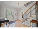 Bright foyer with hardwood floors, staircase, elegant lighting, and detailed trim work at 4423 Windsor Oaks Cir, Marietta, GA 30066