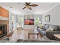Inviting living room featuring a cozy brick fireplace, built-in shelves and large windows at 4423 Windsor Oaks Cir, Marietta, GA 30066