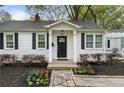Charming home with a welcoming front door, stone walkway, and beautiful flower beds at 502 Allgood Ne Rd, Marietta, GA 30060