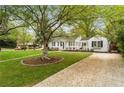 Traditional home with mature landscaping including a beautiful tree and green lawn at 502 Allgood Ne Rd, Marietta, GA 30060