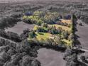 Expansive aerial view of the property surrounded by verdant trees and open fields, showcasing its natural beauty at 1025 Rocky Plains Rd, Covington, GA 30016