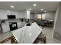 Bright, open kitchen featuring a large island with a marble countertop, modern appliances, and an adjacent dining area at 2657 Mcguire Nw Dr, Kennesaw, GA 30144