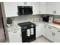 Modern kitchen with white cabinets, granite countertops, a black range, and stainless steel appliances at 2657 Mcguire Nw Dr, Kennesaw, GA 30144