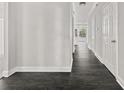 Hallway featuring dark wood floors and light gray walls with white trim and doors at 990 Lilac Arbor Rd, Dacula, GA 30019