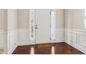 Welcoming foyer with dark hardwood floors, white trim, and a sidelight window at 4970 Roseman Trl, Cumming, GA 30040
