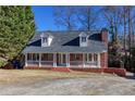 Inviting brick home with a white porch railing, offering a classic and welcoming curb appeal at 6841 Fairway Ridge Dr, Douglasville, GA 30134
