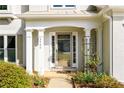 Elegant front entrance with white columns, a decorative storm door, and manicured landscaping at 3545 River Summit Trl, Duluth, GA 30097