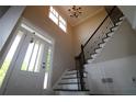 Bright entryway featuring a staircase with black wrought iron railing and a chandelier at 36 Evergreen Way, Dallas, GA 30157
