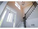 Bright foyer featuring a white front door, window, chandelier, and a staircase with decorative wrought iron railings at 36 Evergreen Way, Dallas, GA 30157