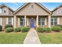 Charming brick home with a covered front porch, neat landscaping, and a vibrant blue front door at 1129 Abundance Dr, Locust Grove, GA 30248