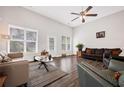 Bright living room with vaulted ceilings, large windows, and hardwood floors featuring a cozy seating area at 1129 Abundance Dr, Locust Grove, GA 30248