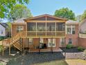 Back of brick home with elevated screened porch, wooden deck with stairs, and patio space at 1670 Bookhout Dr, Cumming, GA 30041
