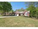 Sprawling front yard showcasing a brick home with a two-car garage and manicured landscaping at 1670 Bookhout Dr, Cumming, GA 30041